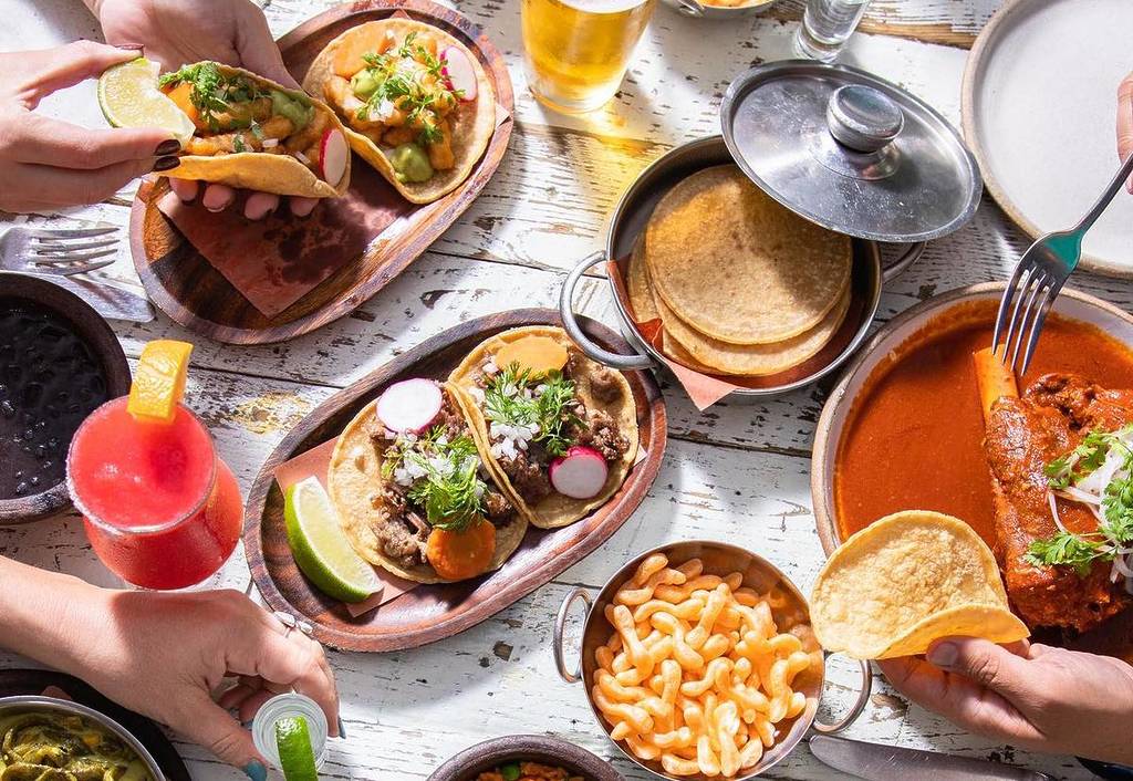 A shared meal of tacos and colorful dishes at Casa Enrique