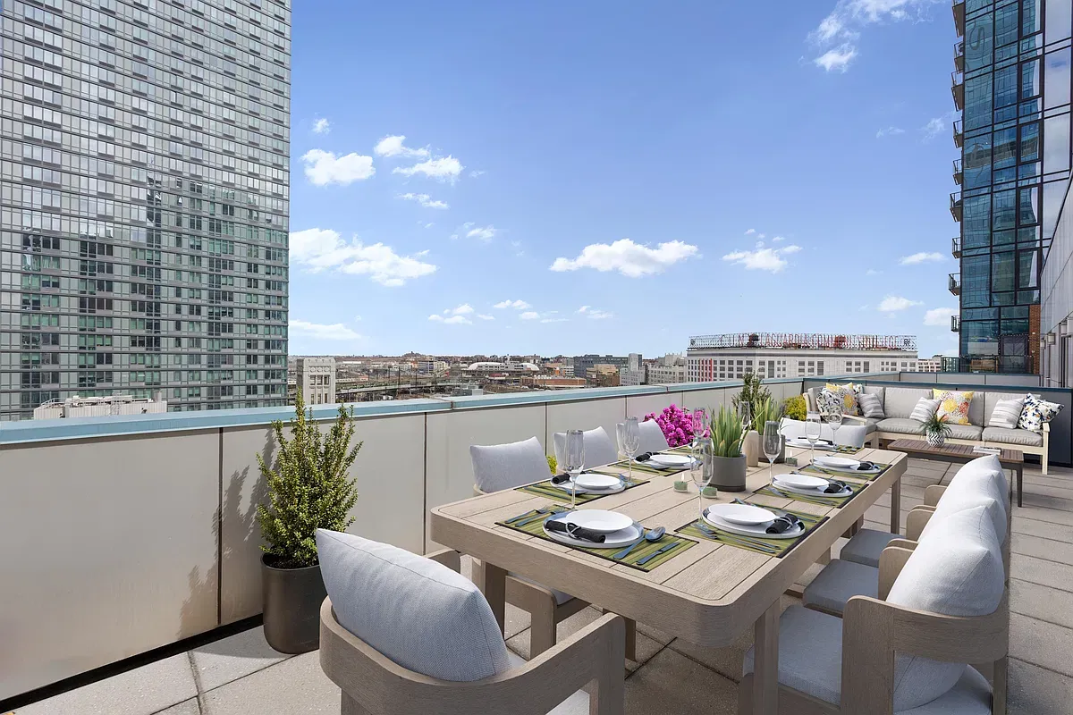 Outdoor dining and lounge areas on the private terrace at 44-27 Purves PH15C