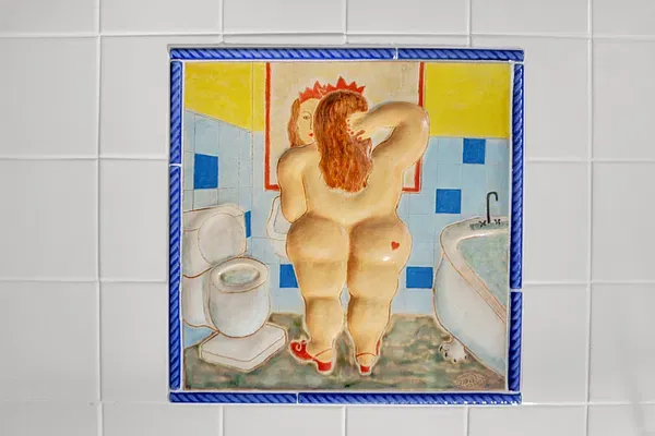 Decorative bathroom tile panel with a figure at a mirror and a blue border